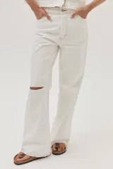 Pantalón de jean blanco, de calce recto y tiro medio-alto. Cuenta con un corte en la rodilla y ruedo desflecado.