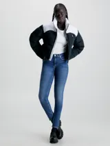 Jeans de denim azul medio vintage, corte skinny, tiro medio, cinco bolsillos y cierre con cremallera.