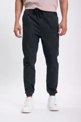 Pantalón jogger de jean color gris oscuro, con cintura elástica y cordón ajustable. Corte holgado con puños elásticos en los tobillos.