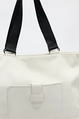 Bolso blanco de símil cuero con terminación suave. Tiene asas anchas de cinta negra y un bolsillo frontal con solapa.