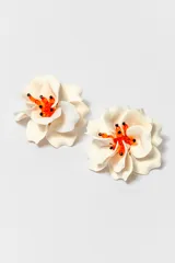 Par de caravanas con forma de flor color crema y centro con cuentas naranjas y negras.