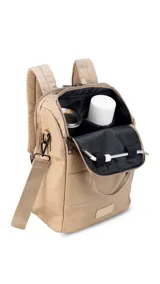 Mochila matera confeccionada en tela impermeable color beige, diseñada con dos compartimientos independientes para el kit de mate y objetos personales. Cuenta con bolsillos internos, asas de mochila acolchadas, asa de mano superior y una correa ajustable extraíble para llevar al hombro.
