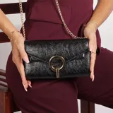 Cartera de mano negra con textura, solapa con cierre de broche metálico dorado y cadena dorada para colgar al hombro.