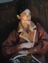 Campera de cuero vacuno color crudo con corderito en la solapa y costuras a mano.