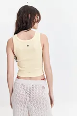 Musculosa color amarillo pastel, acanalada, de fit ajustado y textura suave.