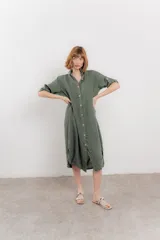 Vestido camisero midi color verde militar, de lino 100%, con silueta oversize, cuello camisero, mangas 3/4 con botón para ajustar y aberturas laterales.