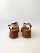 Sandalias con plataforma color beige, con tira ancha sobre los dedos y tira con hebilla al tobillo.