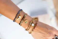 Pulsera de acero quirúrgico con baño de oro, con diseño de doble cadena y piedras naturales en verde oscuro.