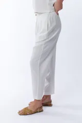 Pantalón blanco de corte tipo carrot, con bolsillos laterales y cintura elástica.