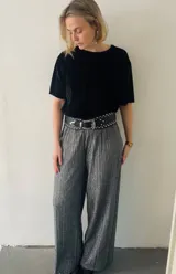 Blusa negra de terciopelo plisado con mangas cortas y cuello redondo.