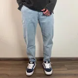 Pantalón jean negro de corte slouchy, con tiro alto y largo al tobillo.