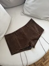 Short marrón de gamuza con cintura alta, corte ajustado y cordones cruzados en los laterales.