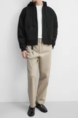 Pantalón chino color verde militar, de corte recto, con bolsillos laterales y traseros de vivo. Cierre frontal con cremallera y botón.