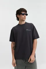 Remera de manga corta color verde grisáceo, corte oversize con cuello redondo y estampado con la frase 'STRAL STYLE ONL' en la espalda.