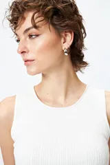 Musculosa de punto color beige, con textura acanalada y detalle de trenzado lateral ajustable.