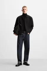 Camisa de punto color negro, corte relaxed fit, con cuello solapa, manga larga y cierre frontal con botones.