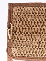 Monedero tipo sobre de paja trenzada color arena con forro negro y tira de agarre.