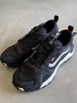 Championes Vans Crosspath XC, color negro, con detalles en gris claro y blanco. Diseñadas para uso todoterreno urbano, cuentan con parte superior de malla de PET reciclado, ante y textiles, tratamiento DWR, suela Vibram XS TREK EVO y entresuela UltraCush™.