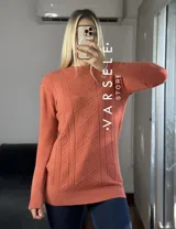 Sweater color salmón con textura en relieve de rombos y líneas verticales.