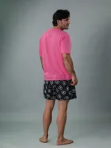 Conjunto de pijama Calvin Klein de dos piezas. Incluye una remera rosa de manga corta con cuello redondo y logo estampado en el pecho, y un short negro con estampado de corazones y logo de la marca.