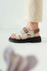 Sandalias con diseño moderno, color beige, con cierre trasero y suela gruesa para mayor comodidad.
