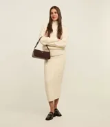 Pollera midi color crema, confeccionada en tejido de punto tricot con bordado de rombos y cintura elástica.