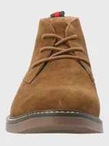 Botín Chukka Hush Puppies modelo New Safari, color marrón, confeccionado en descarne (cuero) con cordones. Presenta suela de TPR de color marrón oscuro con costura decorativa blanca alrededor del borde.