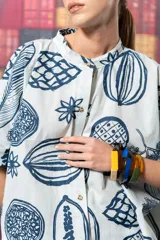 Camisa celeste con estampado de frutas y flores en azul, corte oversize y cuello mao.