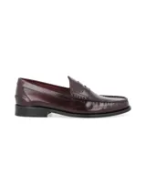 Zapato mocasín de cuero negro con detalle de antifaz y suela plana.