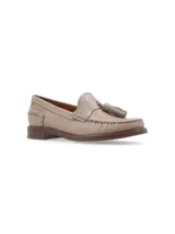 Mocasín de cuero color beige, con borlas ornamentales y puntadas artesanales.