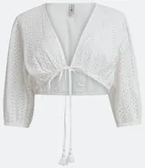 Blusa cropped blanca de laise texturizado con mangas 3/4 ajustadas y lazo en el bajo.