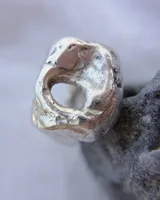 Anillo de plata 925 con diseño irregular y abertura circular en el centro.