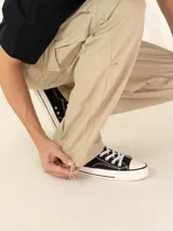 Pantalón cargo color beige, de corte recto y tiro medio, con bolsillos laterales con solapa y logo de la marca bordado en la pierna.
