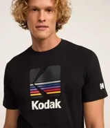 Remera negra de algodón con cuello redondo y manga corta. Estampado frontal con el logo de Kodak a la altura del pecho.
