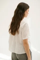 Camisa blanca de mangas cortas con estampado de hojas.