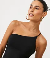 Vestido corto negro de jersey con escote de un solo hombro y tirante fino cruzado. Presenta fruncidos en la espalda.