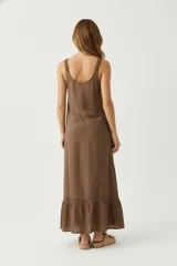 Vestido largo de algodón color rojo, sin mangas y con cuello redondo. Presenta una pechera con botones frontales parciales y un diseño holgado que termina en un ruedo con volado y detalle de puntilla.