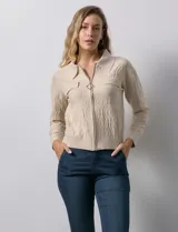 Cardigan color beige en tejido jacquard, con cuello con solapa y abertura central con cierre. Delantera con bolsillos simulados.