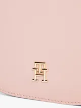 Cartera saddle Tommy Hilfiger color rosa con correa de textil trenzado con inscripciones de la marca y logo TH brillante en el frente.