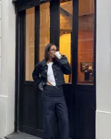 Campera corta de jean azul oscuro con cuello clásico, cierre con botones metálicos y bolsillos frontales.