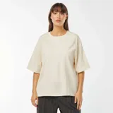 Camiseta beige de cuello redondo y corte oversize.