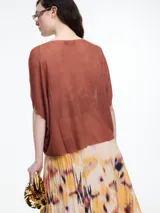 Top de punto color marrón con lurex, de silueta amplia, manga caída y escote redondo.