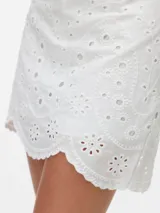 Short pollera blanco de tejido plano de algodón con detalle de puntilla calada.