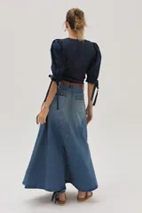 Falda larga de jean celeste con corte evasé, tiro medio y detalles bordados en el frente.
