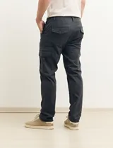 Pantalón de gabardina color marrón, corte slim fit, con bolsillos laterales tipo cargo.