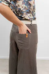 Pantalón de pierna ancha color marrón, con tiro medio y costuras a contratono.