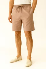 Bermuda color marrón claro, de corte recto y calce medio, con cintura elastizada ajustable con cordón y bolsillos laterales.