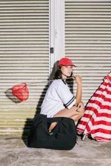 Bolso deportivo tipo duffel bag de nylon color negro, con asas de mano y correa ajustable para hombro. Diseño simple y funcional.