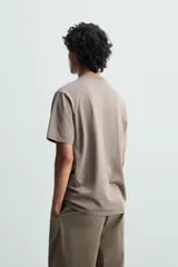 Camiseta blanca de algodón de peso medio, corte recto, cuello redondo y mangas cortas.