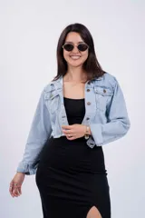 Campera de jean celeste de corte cropped, con cuello clásico, botones metálicos y mangas largas.